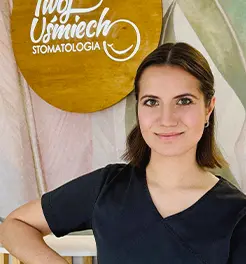 Portret uśmiechniętej kobiety w czarnym fartuchu medycznym na tle logo „Twój Uśmiech Stomatologia”.