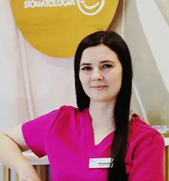 Portret uśmiechniętej kobiety w różowym fartuchu medycznym, na tle logo gabinetu stomatologicznego.