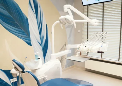 Nowoczesny niebieski fotel dentystyczny w jasnym gabinecie stomatologicznym.